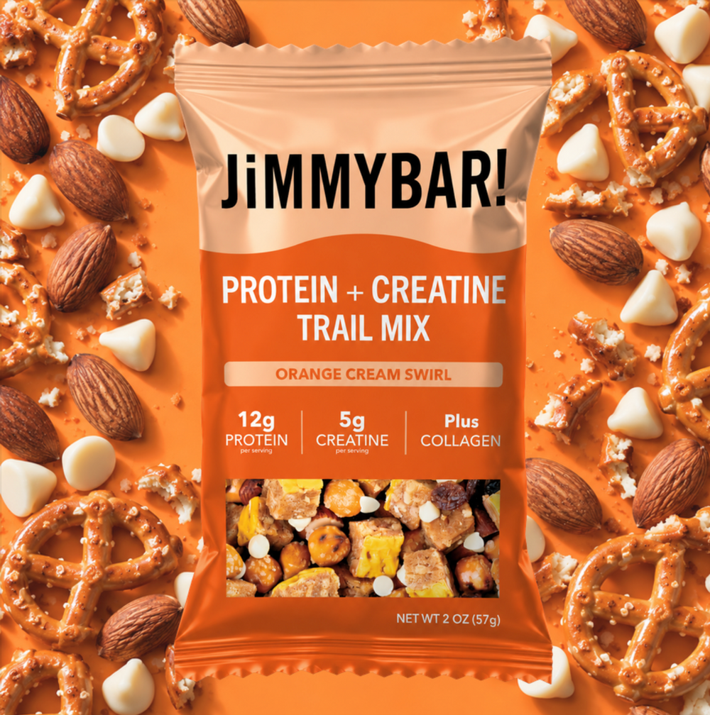 A bag of Jimmybar! Protein + Creatine Trail Mix in Orange Cream Swirl flavor, surrounded by pretzels, almonds, and white chocolate pieces on a bright orange background.